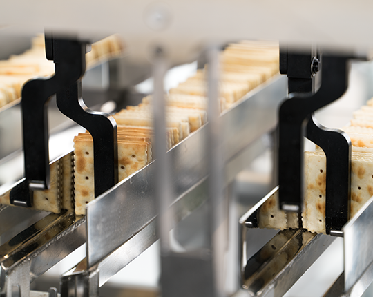 Das automatisierte On-Edge-Handling-System von Syntegon richtet Cracker für eine hocheffiziente Verpackung präzise aus